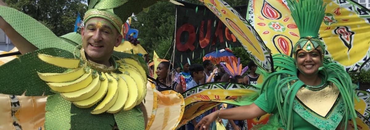 Image of two people dressed in bright green and yellow outfits for Quaggy Festival. The photo was taken in 2019