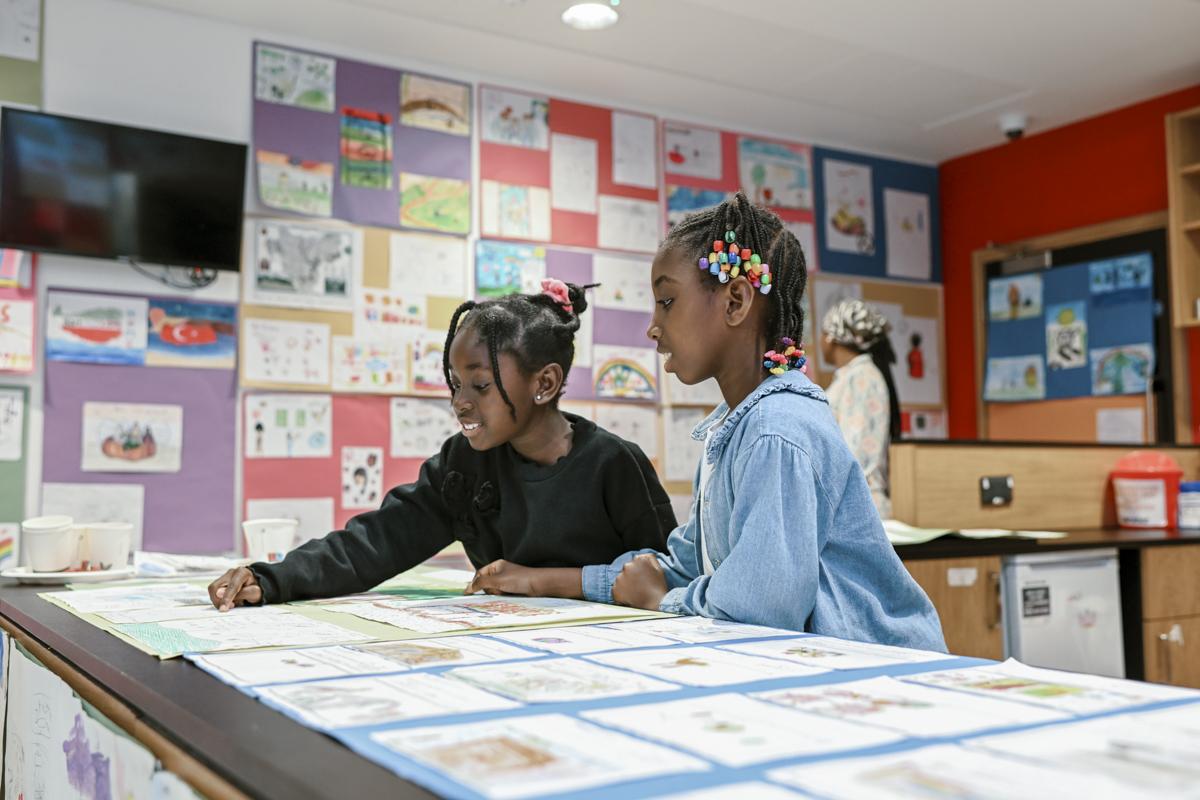 Two children who participated in the Borough of Sanctuary art exhibition looking at their art