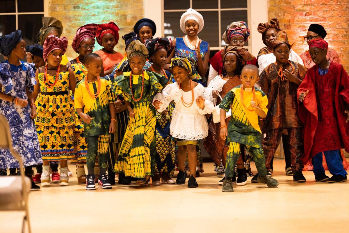 Our Heritage UK event with children and members dressed in traditional outfits.