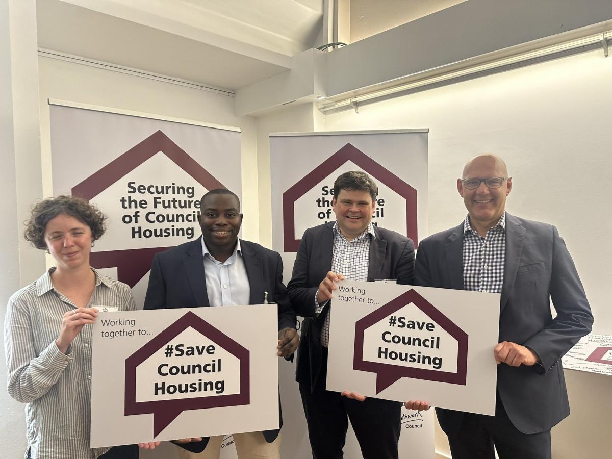 Leader and senior council officers holding signs with words: Securing the Future of Council Housing