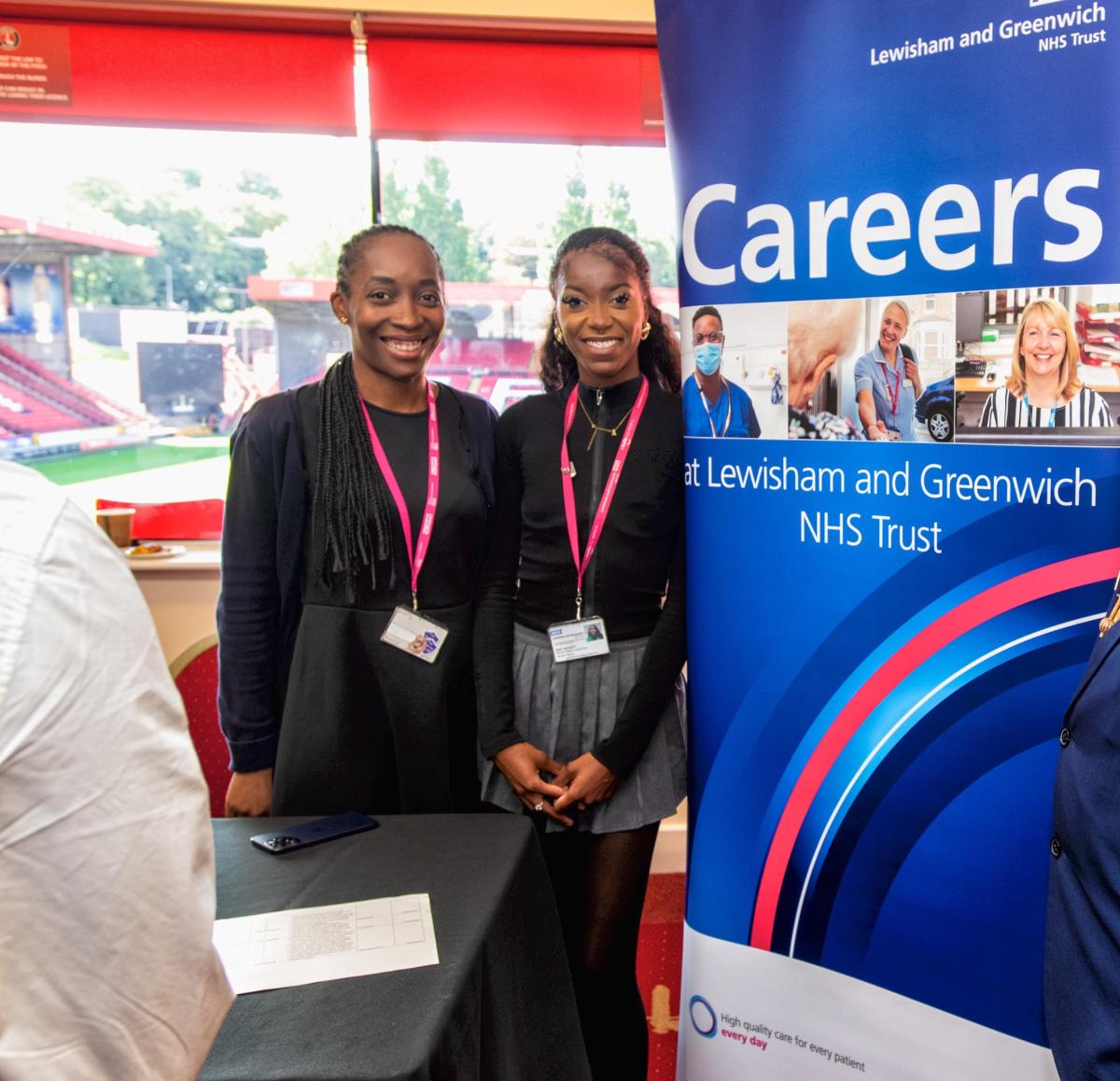 Two people smiling next to a pop-up banner that says 'Careers' at Lewisham and Greenwich NHS Trust