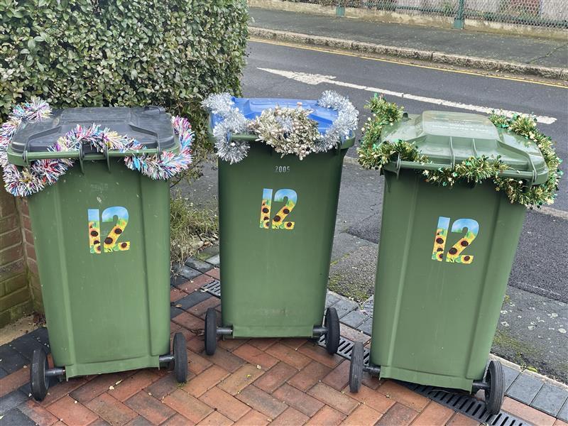 Image of bins, with tinsel decorating them