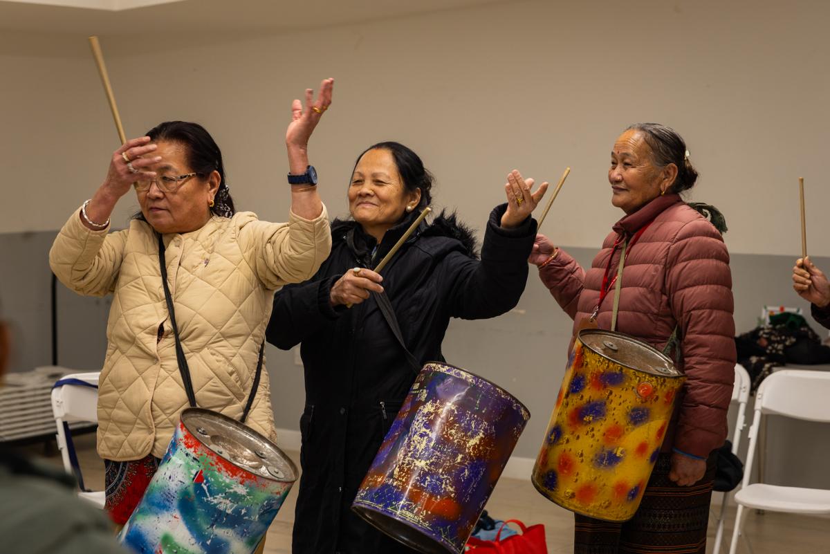 Three women playing the drums