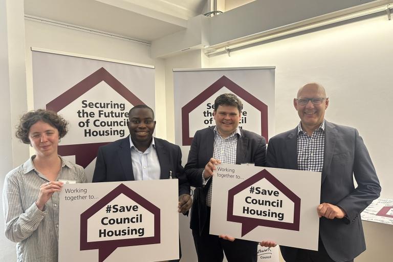 Leader and senior council officers holding signs with words: Securing the Future of Council Housing