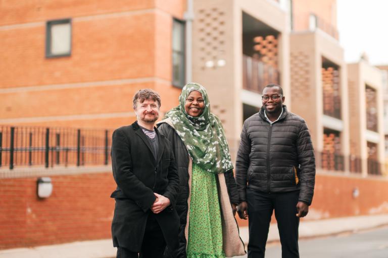 Cllr Anthony Okereke and Cllr Aidan Smith with a tenant outside new council homes at Bliss Crescent.