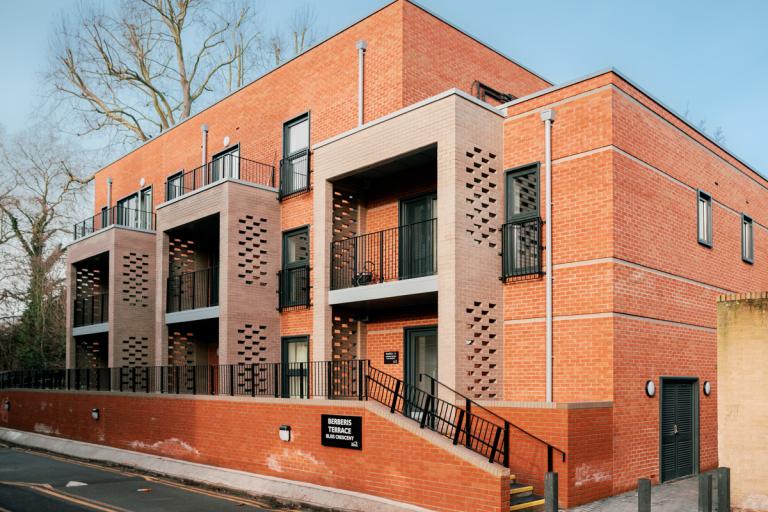 The new development of council apartments at Bliss Crescent, in a single three-storey block with a modern red brick design and balconies in brown brick.