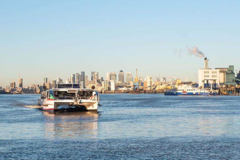 A photo of a boat sailing along the Thames riverfront.