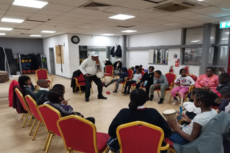 A group of children enjoying a drumming workshop. 