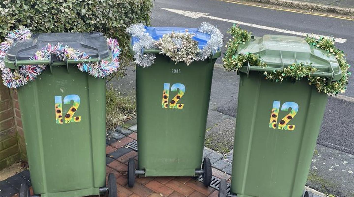 Image of bins, with tinsel decorating them